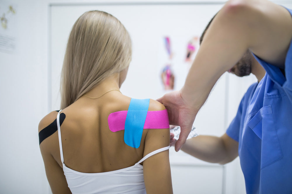 Athlete preparing for training with kinesiology tape, water, and Sting-Less adhesive remover