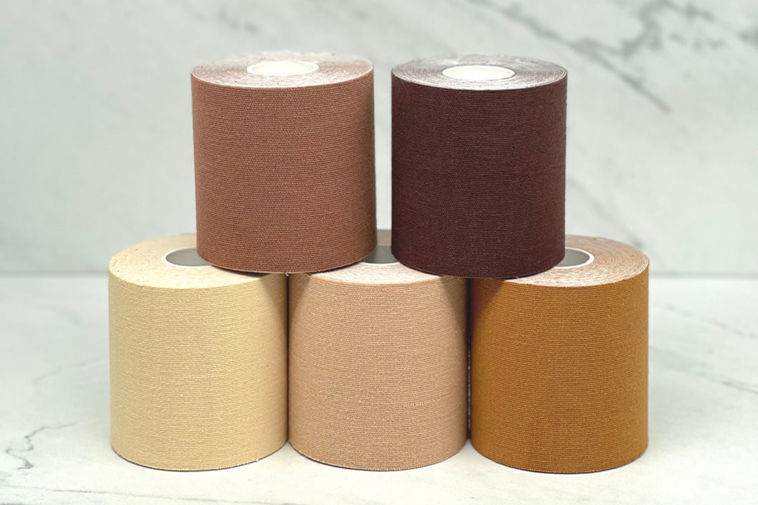 Roll of skin-tone breast tape next to Sting-Less adhesive remover spray bottle