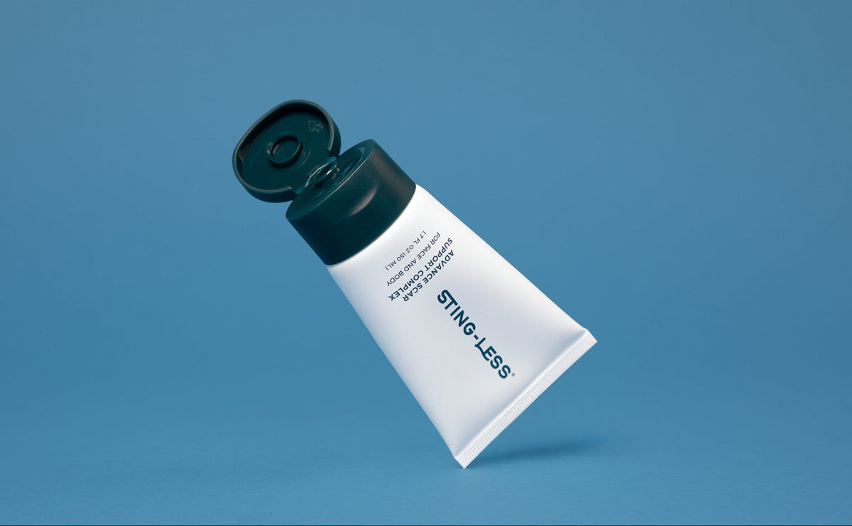 Sting-Less Scar Gel tube with the cap open on a blue background